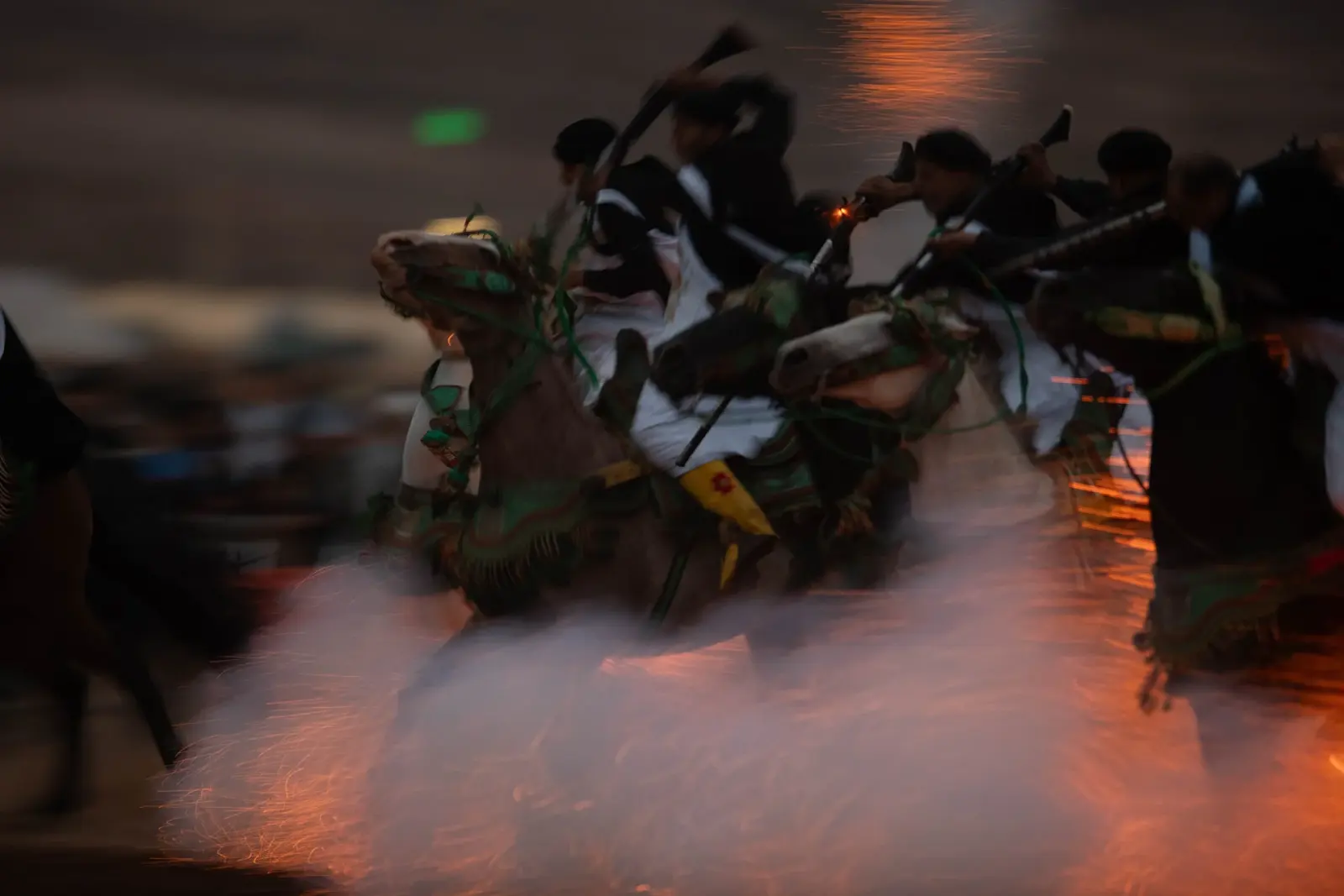 Traditional Moroccan Fantasia show with horse riders and colorful festive lighting